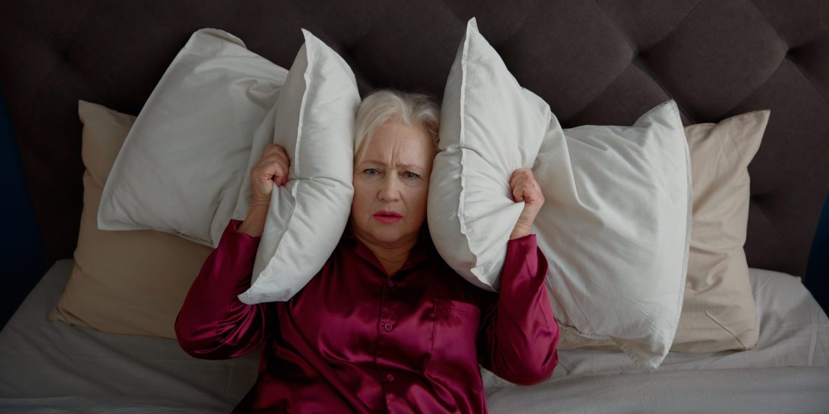 Mulher não consegue dormir por causa do zumbido no ouvido.